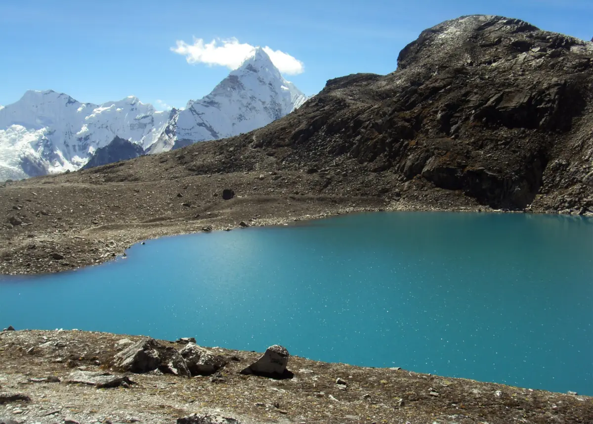 Un lago glaciale turchese lungo il sentiero del Kongma La con l'Ama Dablam in lontananza
